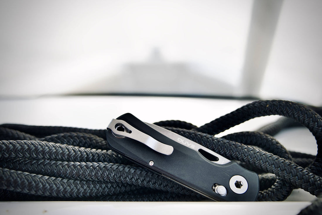  Close-up of everyday carry knife USA blade on oak surface