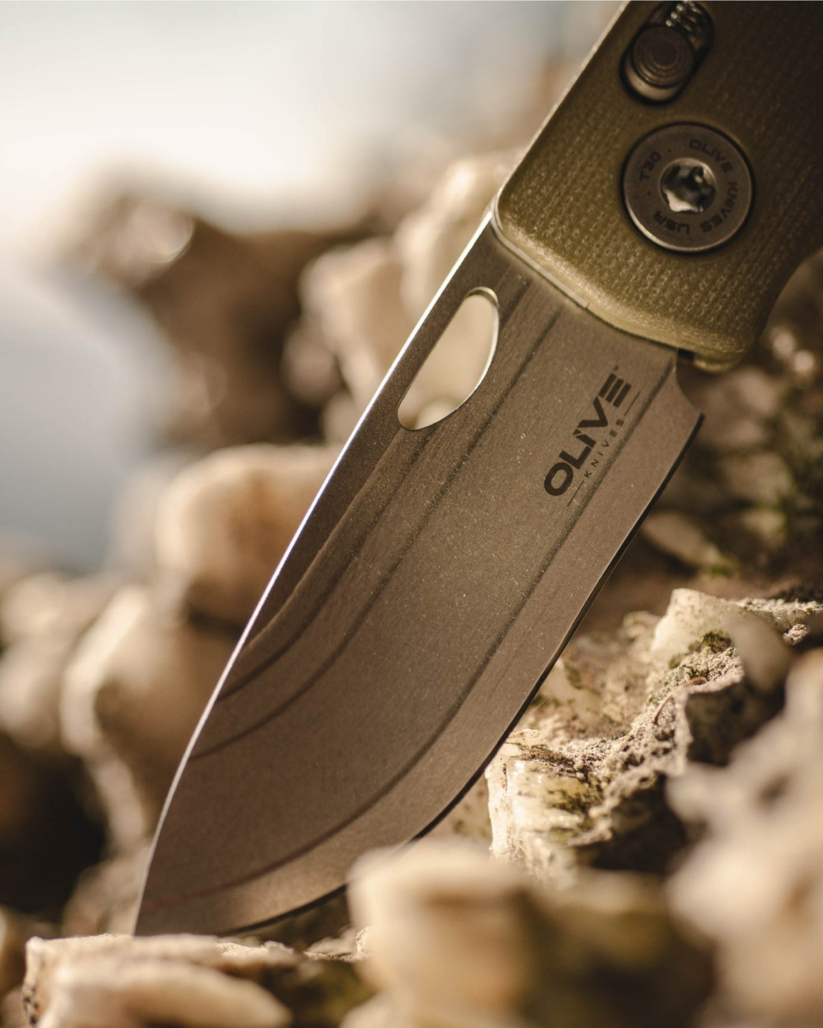 Olive Knives LENTA EDC folding knife, Elmax steel — lifestyle, close-up on rocky terrain